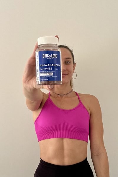 Creadora fitness mostrando suplemento Ashwagandha Gummies de Chic&Love Wellness en un entorno minimalista.