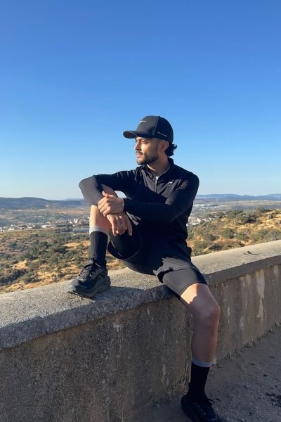 Julio Alcón García descansando durante una ruta deportiva al aire libre con vistas panorámicas a un paisaje montañoso.