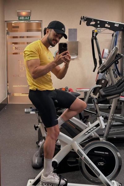 Julio Alcón García realizando una sesión de entrenamiento en bicicleta estática dentro de un gimnasio.