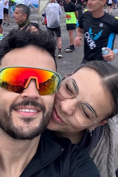Julio Alcón García junto a una acompañante durante un evento de running, sonriendo tras una jornada deportiva al aire libre.