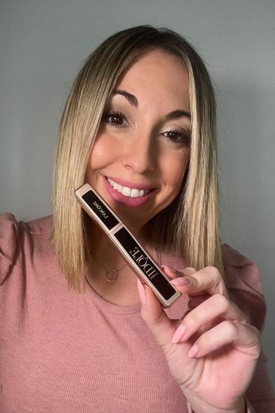 Laura Domínguez González mostrando un lápiz labial Lancôme con una sonrisa.