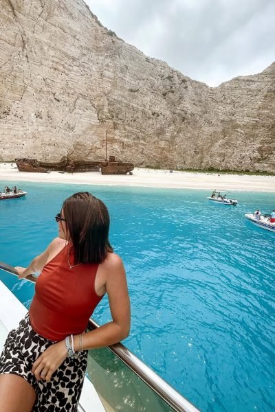 Laura Freyta disfrutando de un viaje en barco frente a una playa paradisíaca de aguas turquesas, creando contenido UGC de lifestyle y viajes.