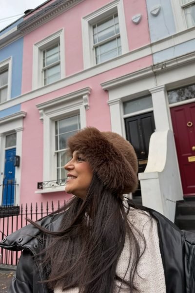 Laura Freyta disfrutando de un viaje urbano con un look de invierno frente a las icónicas casas de colores de Londres, creando contenido UGC de lifestyle, moda y viajes.