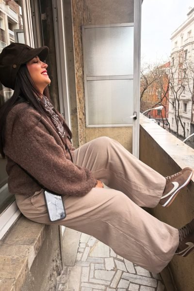 Laura Freyta relajándose en el balcón durante un viaje urbano, compartiendo contenido UGC de lifestyle, moda y bienestar.