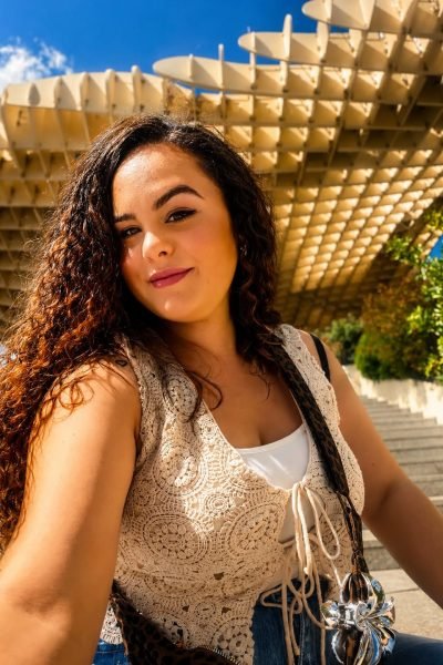 Laura Postigo sonriendo frente a estructura moderna de madera