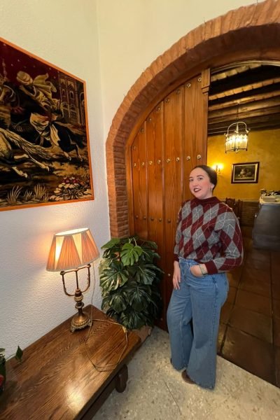 Lola Martín González posando frente a una entrada de una casa.