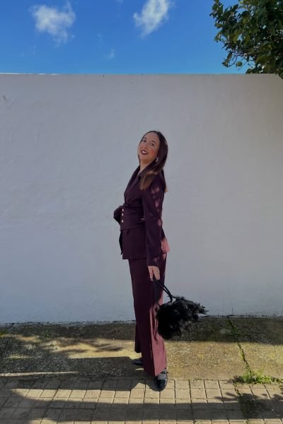 Lola Martín González posando con un conjunto de traje en color burdeos.