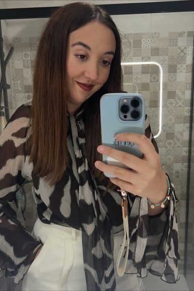 Lola Martín González mostrando un conjunto con blusa de estampado animal print y pantalón blanco.