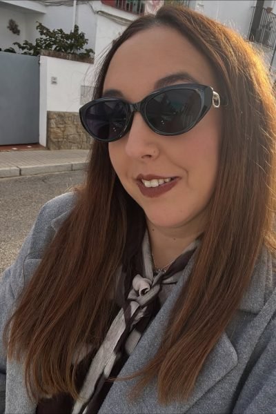 Lola Martín González usando gafas de sol y abrigo gris.