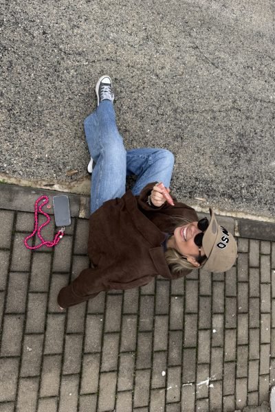 Lucía Cardona sentada en la acera con un estilo casual.