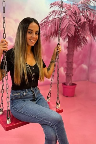 Maite Gañan UGC disfrutando en columpio con fondo rosa Agencia de marketing digital Brilla influencers y comunicación