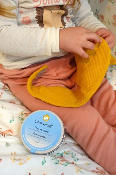 niño jugando con muselina amarilla producto para dormir Löwenkind bienestar infantil