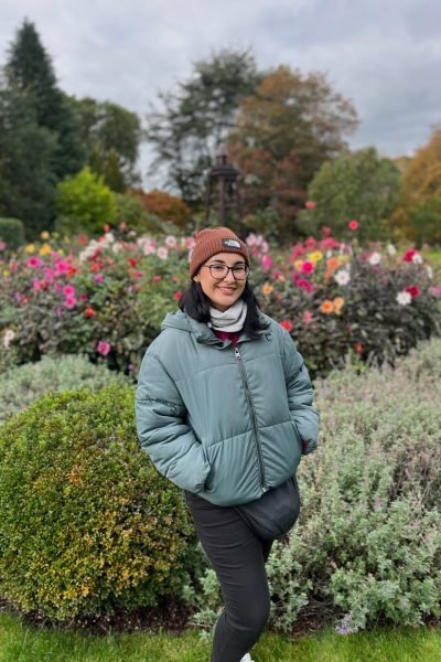 María Montero Martínez en parque con chaqueta verde y gorro mostrando sonrisa