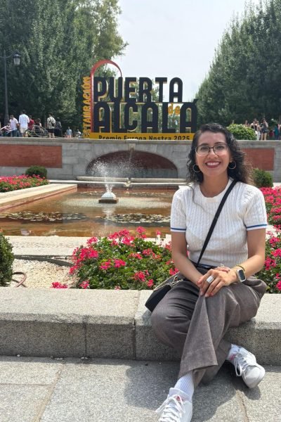 María del Carmen Ramírez, creadora UGC, disfrutando de la Puerta de Alcalá en Madrid, con una vista vibrante y ambiente cultural.