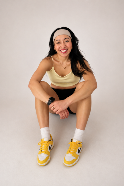Mariana Araujo en estudio con ropa deportiva, zapatillas y smartwatch, representando un estilo de vida fitness y saludable.
