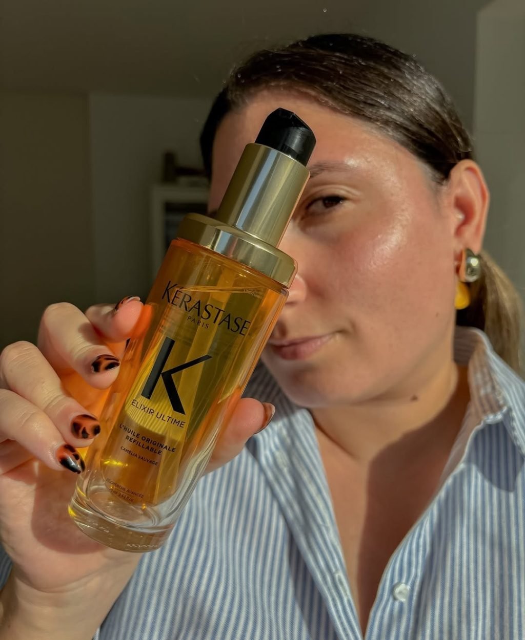 Mariana Samele mostrando aceite Elixir Ultime de Kerastase para cabello, contenido UGC belleza