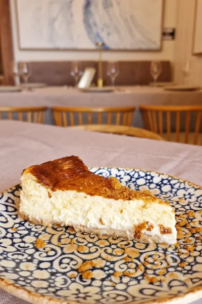 Tarta de queso servida en un plato con un diseño floral, perfecta para postres.
