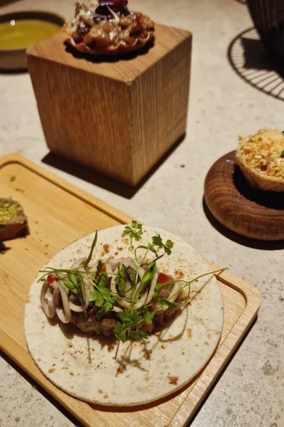 Tacos gourmet con carne y vegetales, servidos con un toque fresco de hierbas.