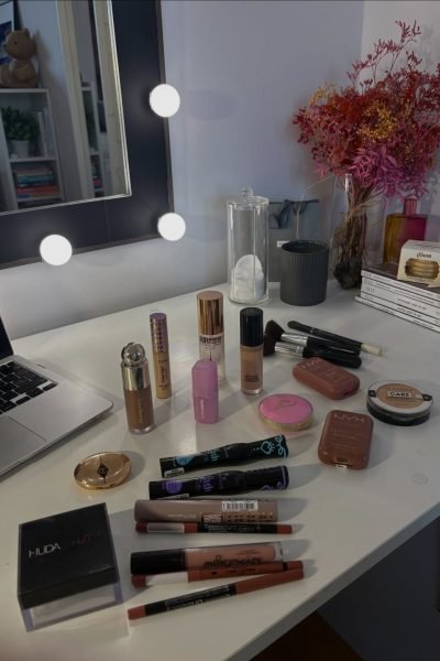 Lápices de labios y productos de maquillaje alineados sobre una mesa.