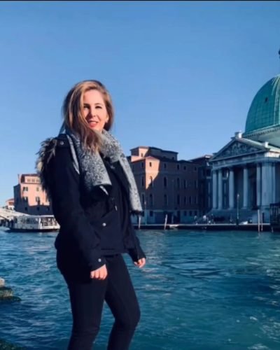 UGC Miriam Garcia Fernandez posando junto a canal en ciudad europea con arquitectura histórica. Imagen de la Agencia de marketing digital Brilla influencers y Comunicación.