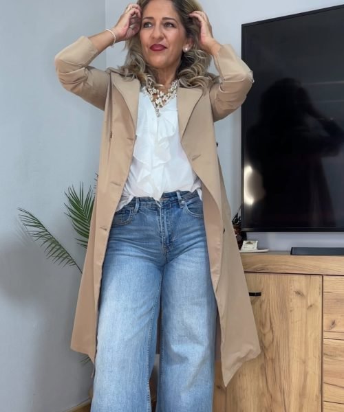 Noemí Bayona con look casual elegante combinando blazer beige, blusa blanca y vaqueros.