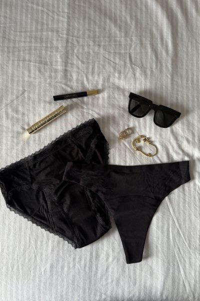 Una toma que muestra productos personales de Paula Alsina, incluyendo lencería, gafas de sol y cosméticos, todo dispuesto de manera ordenada.