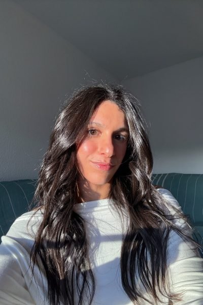 Primer plano de Paula Alsina, con la luz suave resaltando su rostro y su cabello natural, mostrando su autenticidad.