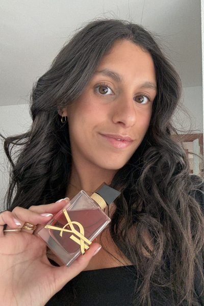Paula Alsina posando en un ambiente relajado mientras sostiene su producto de belleza favorito, mostrando la belleza de los detalles.
