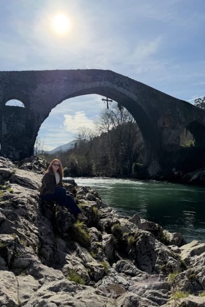 Paula Álvarez Fernández posando junto a un puente histórico, disfrutando de su aventura.