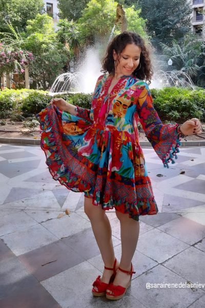Sara de las Nieves Alvarez con vestido colorido en un parque con fuente, contenido UGC para la Agencia de marketing digital Brilla Influencers y Comunicación