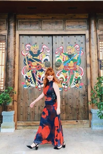 Sara Ramajo posando frente a una puerta decorada de inspiración oriental durante una experiencia de viaje y lifestyle.