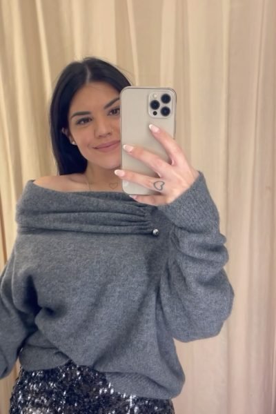 Laia Barruelo Blasco mostrando un look con jersey gris y pantalón de lentejuelas frente al espejo | Agencia Brilla Influencers.