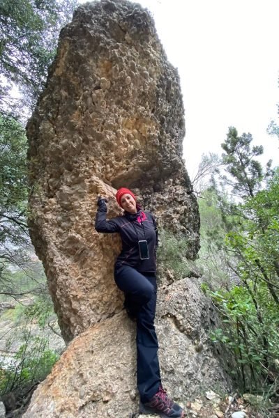 Susanna Ayala Garcia con un atuendo de senderismo, posando cerca de una roca gigante.