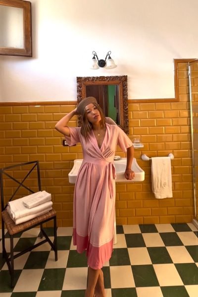 Creadora UGC Ana Yao Gómez López con vestido rosa en el baño de un alojamiento – Agencia Brilla.