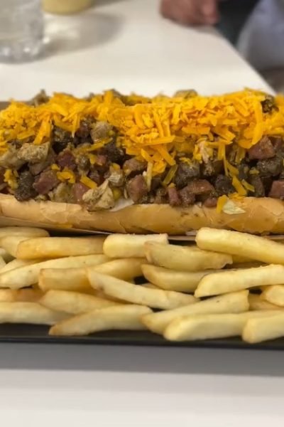 Plato foodie con bocadillo, carne, queso y patatas para contenido gastronómico – Agencia Brilla.