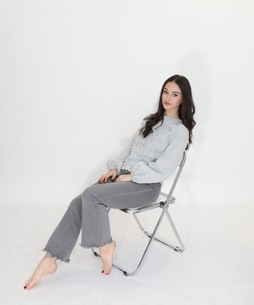 UGC Silvia Santamaria sentada en una silla en estudio fotográfico con fondo blanco. Imagen de la Agencia de marketing digital Brilla influencers y Comunicación.