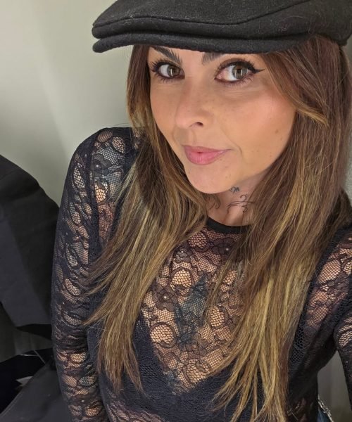 Veronica Villegas con camiseta de manga larga negra y gorra negra, mostrando un look casual.