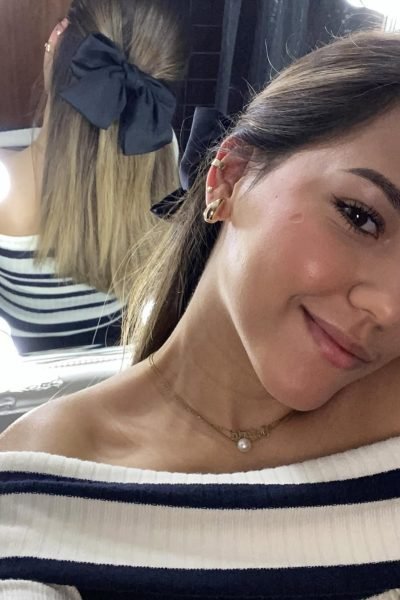 UGC Victoria Valero con lazo negro en peinado y estilo elegante frente a espejo. Imagen de la Agencia de marketing digital Brilla influencers y Comunicación.