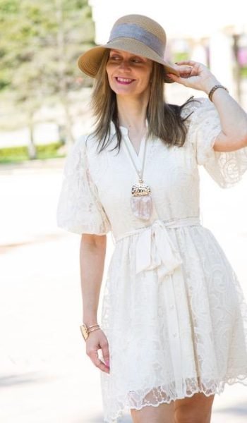 Virginia Sempere posando con un vestido blanco mientras usa un sombrero.