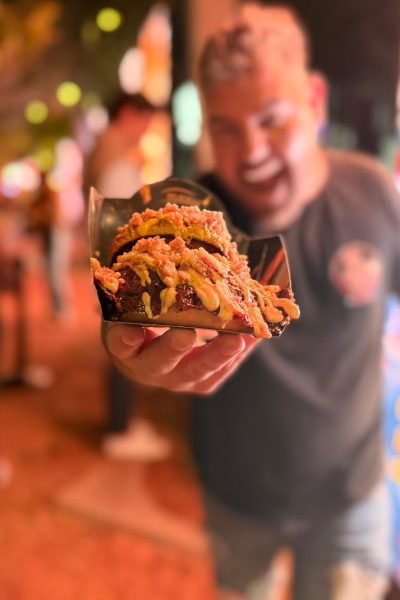 hombre mostrando hamburguesa con bacon y queso comida restaurante ugc