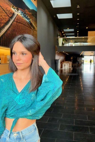 Ylenia Peláez posando en el exterior de un edificio con un conjunto verde.