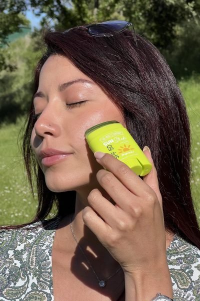 UGC Andrea Panta creadora de contenido beauty y skincare mostrando protector solar en stick SPF 50 en exterior