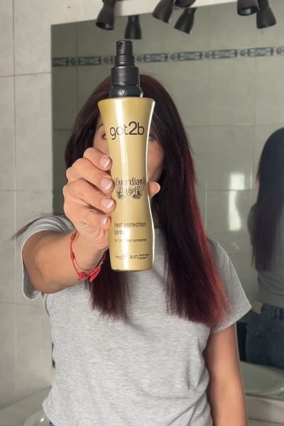 Andrea Panta sosteniendo spray protector de calor got2b, creadora UGC mostrando producto de cabello