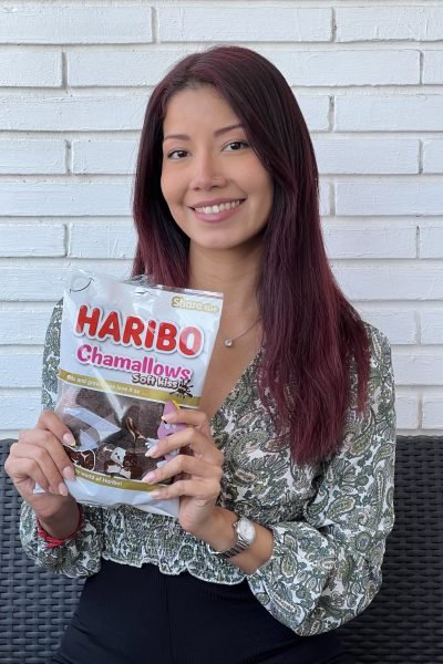 Andrea Panta sonriendo mientras sostiene un paquete de Haribo Chamallows, creadora UGC mostrando producto