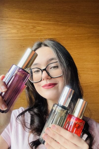 Andrea Suárez sosteniendo perfumes y productos de belleza frente a la cámara, mostrando su experiencia como creadora UGC.