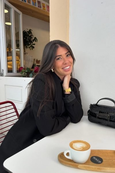 Cristina Jiménez UGC sonriendo mientras disfruta de un café en Waco Specialty Coffee, con un look elegante y casual.