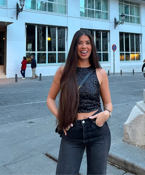 Cristina Jiménez UGC posando con un outfit negro frente a un edificio moderno, mostrando su estilo en las calles.