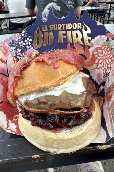 Hamburguesa gourmet con pan brioche, queso fundido, cebolla caramelizada y carpaccio de ternera en El Surtidor On Fire.