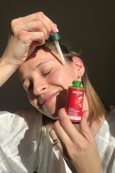 Alexandra Suciu aplicando un serum Weleda en su rostro, mostrando su rutina de cuidado personal con productos naturales.