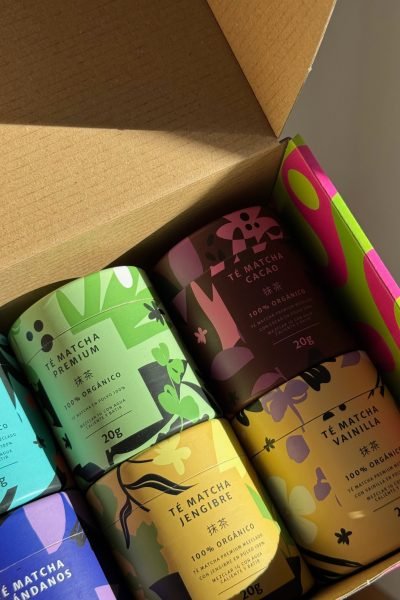 Paquetes de té matcha orgánico en una caja, con envases coloridos y etiquetas visibles.